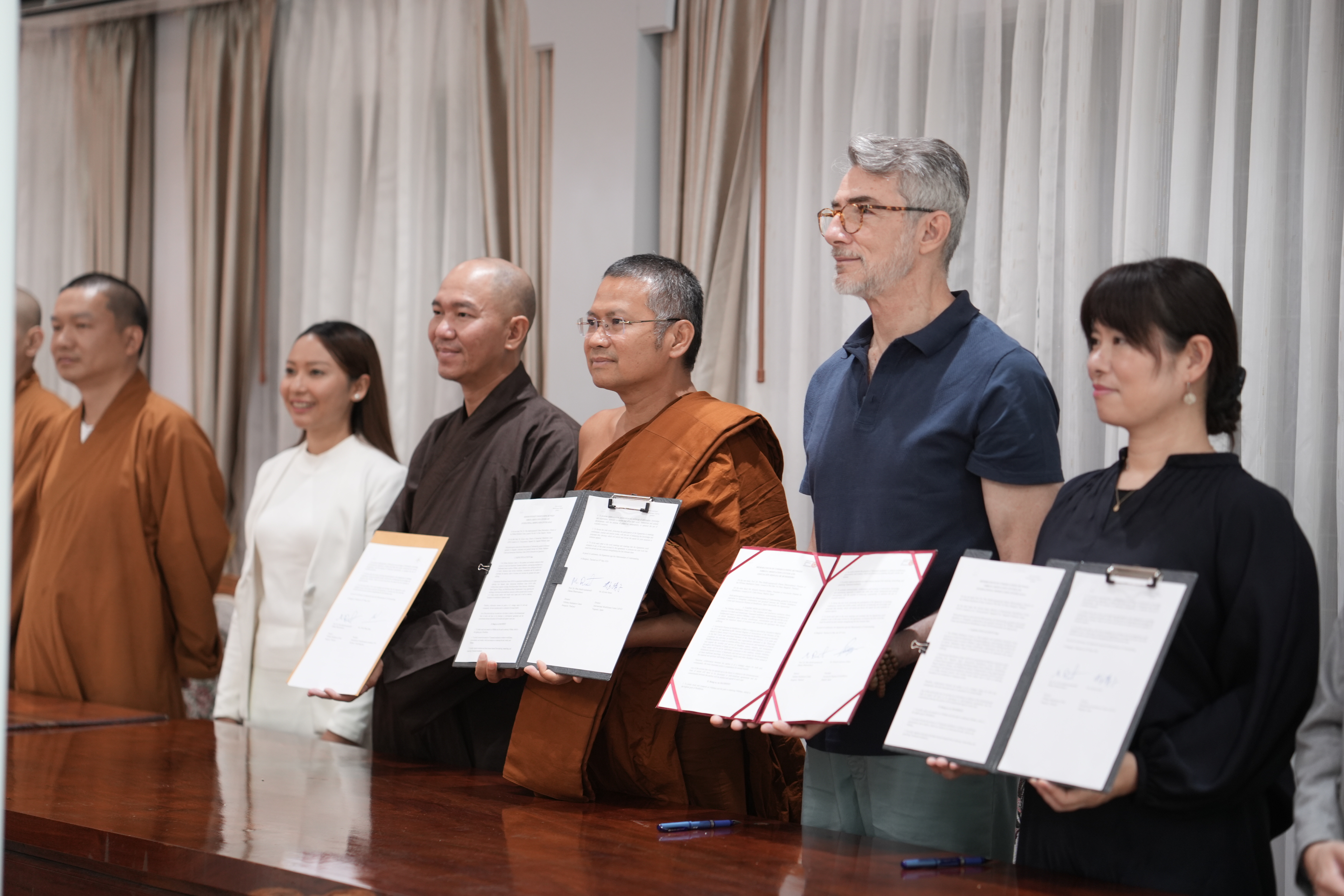 Representatives of the Global Vipassana Network holding signed memorandum documents at the MOU signing.