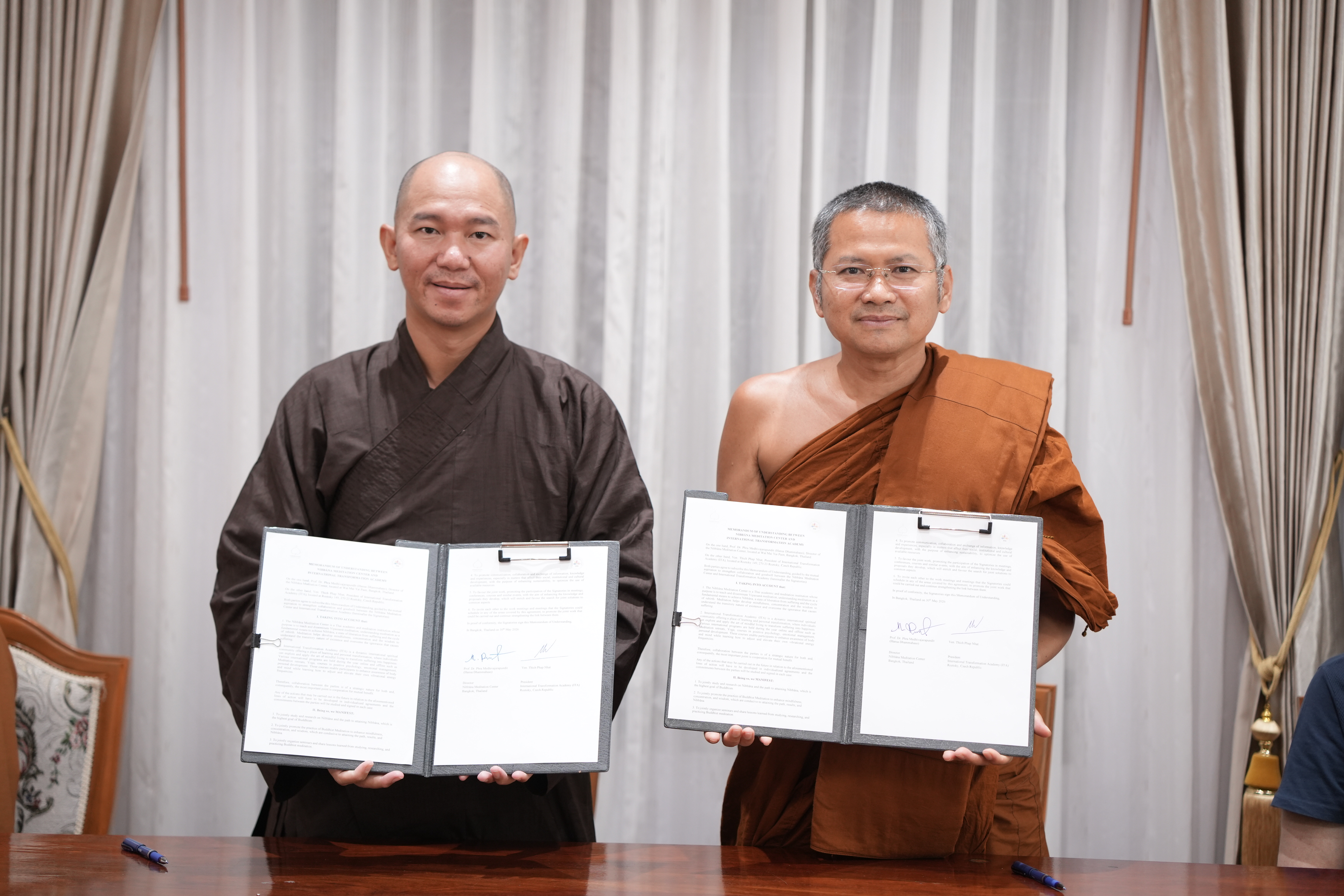 Ven. Thich Phap Nhat and Ven. Prof. Dr. Medivajarapundit (Hansa Dhammahaso) holding signed MOU documents.