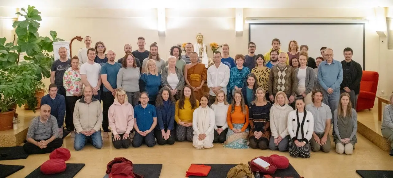 Group portrait of Global Vipassana Network practitioners and teachers gathered in a meditation hall.